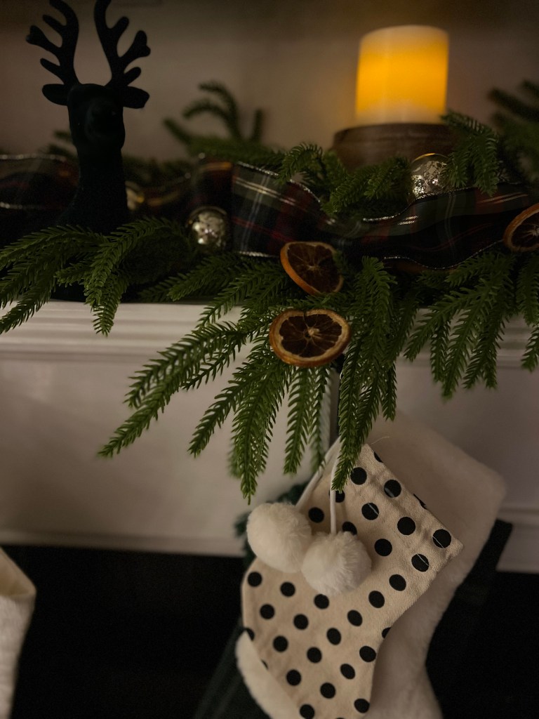 Dried orange slice ornaments hanging on a natural garland on the mantel